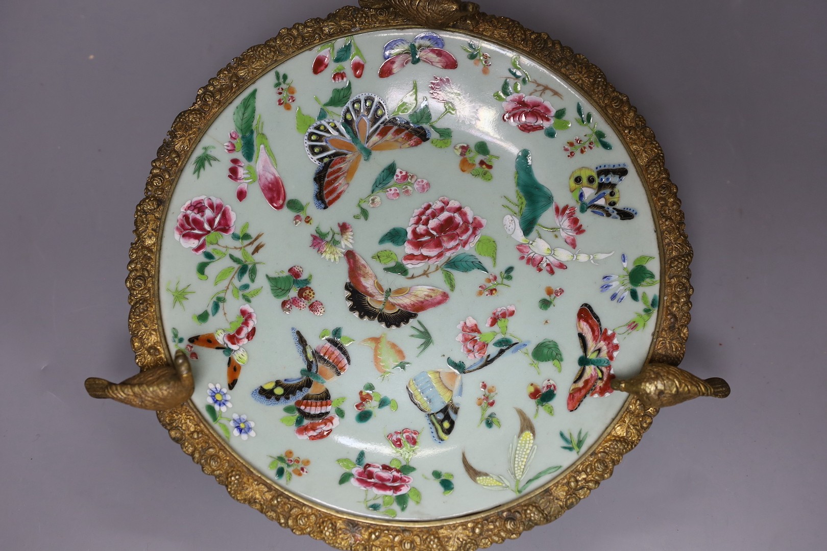 A 19th century Chinese famille rose dish with ormolu mount, 29 cms diameter.